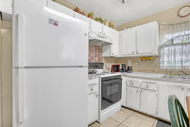 kitchen with white appliances, sink, backsplash, light tile patterned floors, and white cabinetry