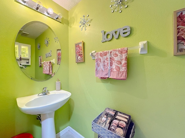 bathroom with a textured ceiling and sink