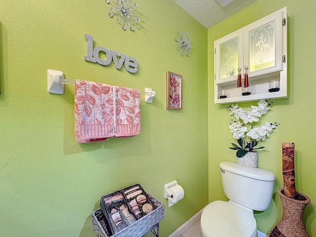 bathroom with toilet and a textured ceiling