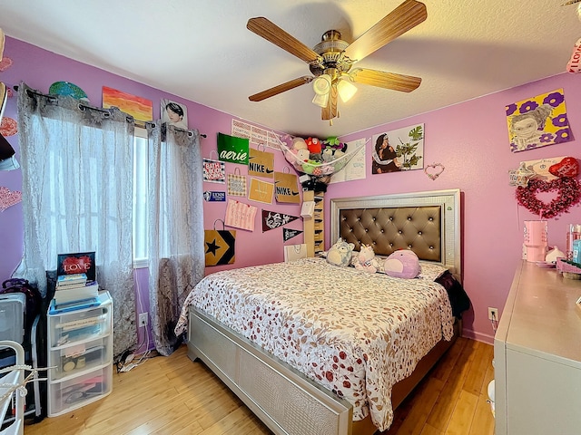 bedroom with a textured ceiling, light wood-type flooring, and ceiling fan