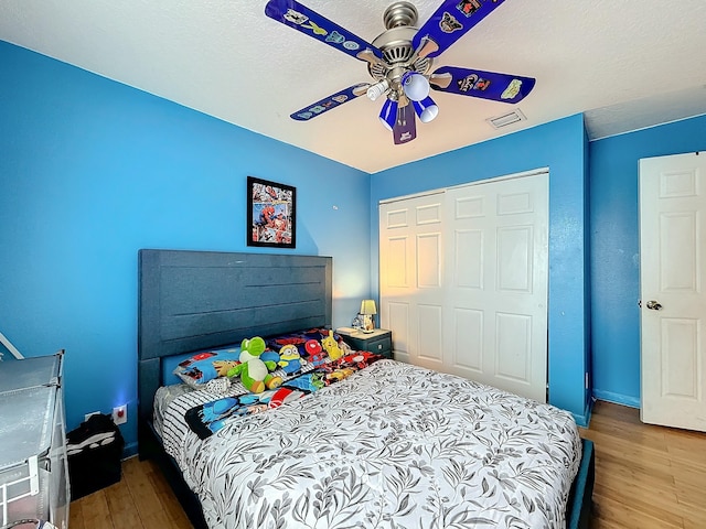 bedroom with ceiling fan, a closet, a textured ceiling, and hardwood / wood-style flooring