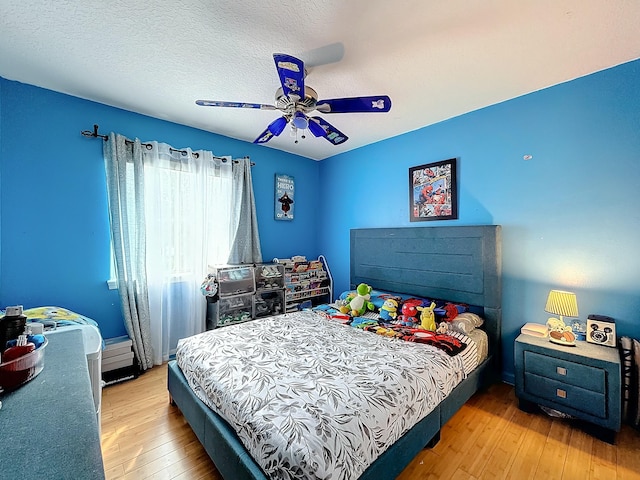 bedroom featuring a textured ceiling, light hardwood / wood-style floors, and ceiling fan