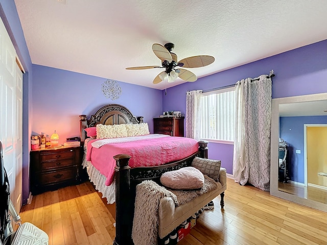 bedroom featuring ceiling fan, light hardwood / wood-style flooring, and a textured ceiling