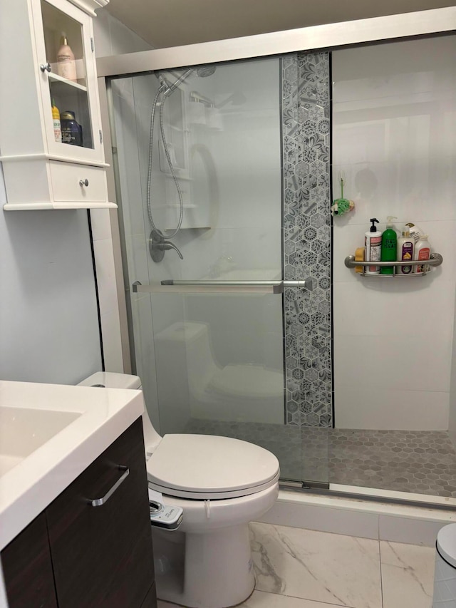 bathroom with an enclosed shower, vanity, tile patterned floors, and toilet