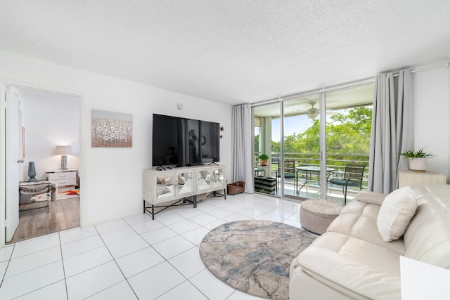 living room featuring expansive windows, light tile patterned floors, and a textured ceiling