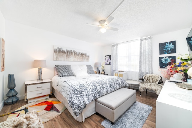 bedroom with hardwood / wood-style flooring, ceiling fan, and a textured ceiling