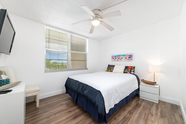 bedroom featuring hardwood / wood-style flooring, a textured ceiling, and ceiling fan