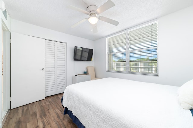 bedroom with ceiling fan, a textured ceiling, hardwood / wood-style flooring, and a closet