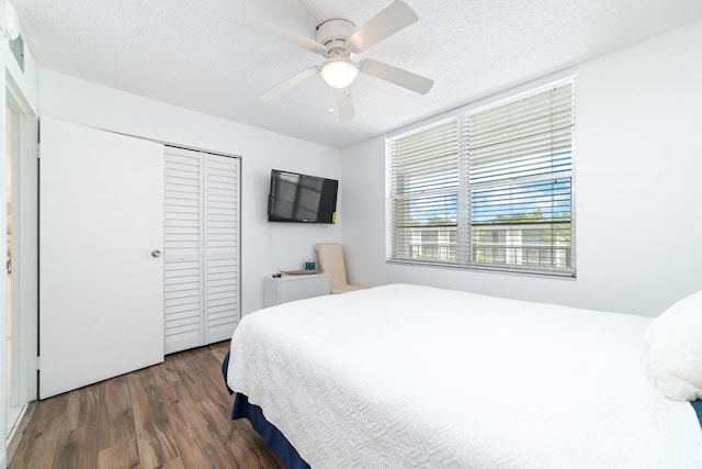 bedroom featuring ceiling fan, a closet, dark hardwood / wood-style flooring, and a textured ceiling