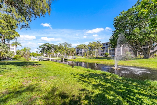 view of home's community featuring a water view and a lawn