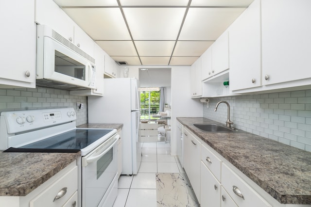 kitchen with decorative backsplash, sink, white appliances, and white cabinets