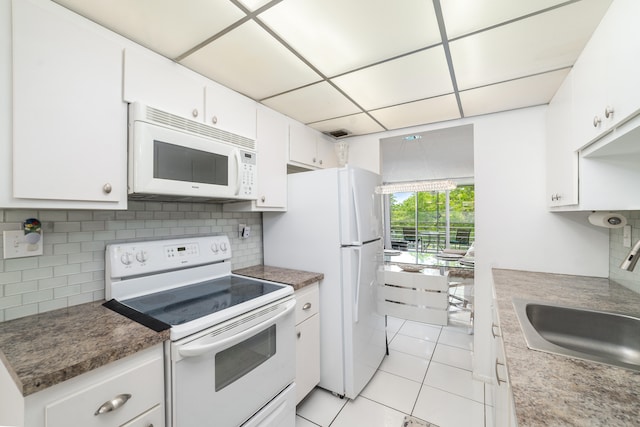 kitchen featuring light tile patterned flooring, white appliances, white cabinets, backsplash, and sink