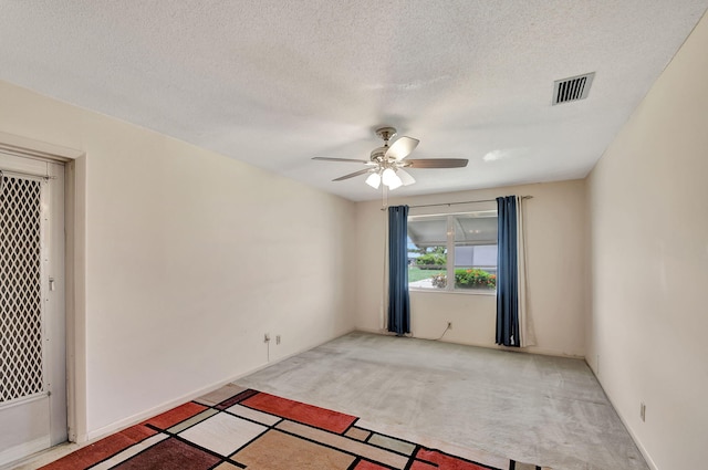 spare room with carpet flooring, a textured ceiling, and ceiling fan