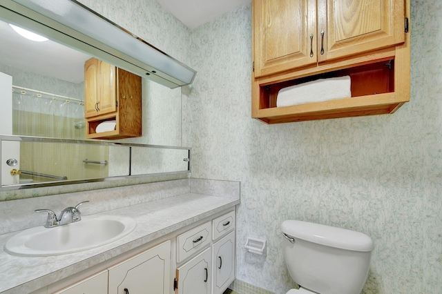 bathroom featuring toilet, vanity, and walk in shower