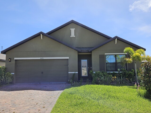 view of front of house with a garage and a front lawn