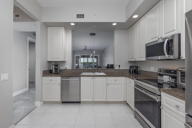 kitchen featuring stainless steel appliances, white cabinetry, and sink