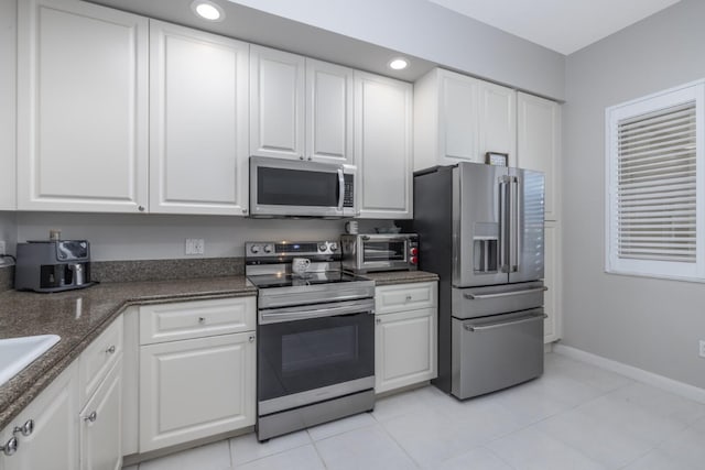 kitchen featuring white cabinetry, appliances with stainless steel finishes, and light tile patterned floors