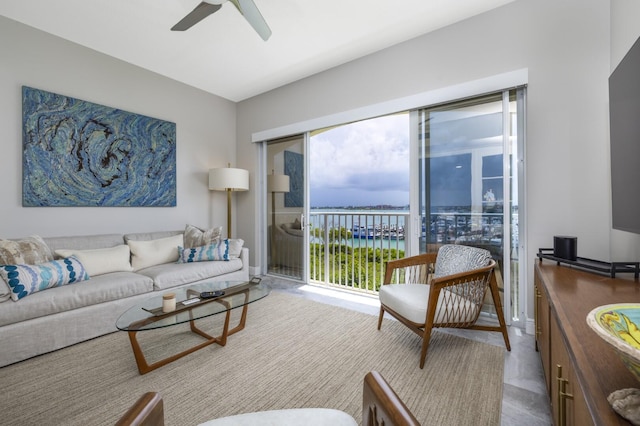 living room with a water view and ceiling fan