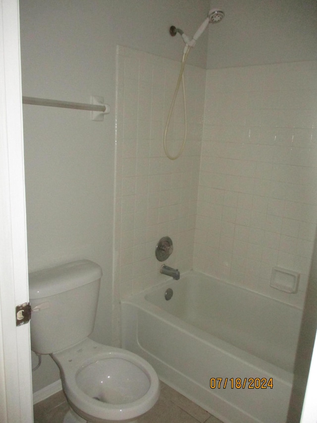 bathroom with tile patterned floors, toilet, and tiled shower / bath