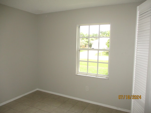 unfurnished room with light tile patterned flooring and plenty of natural light