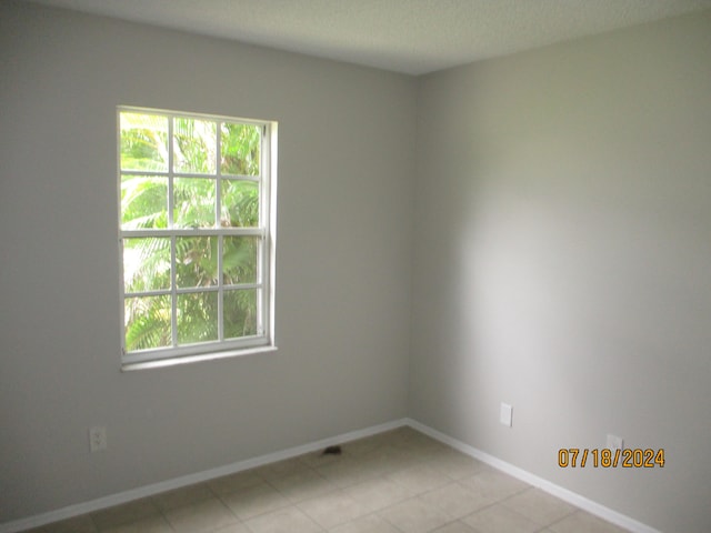 tiled empty room with a healthy amount of sunlight