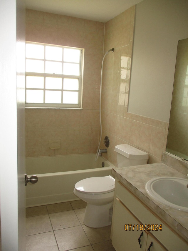 full bathroom featuring tile patterned flooring, tile walls, toilet, vanity, and tiled shower / bath combo