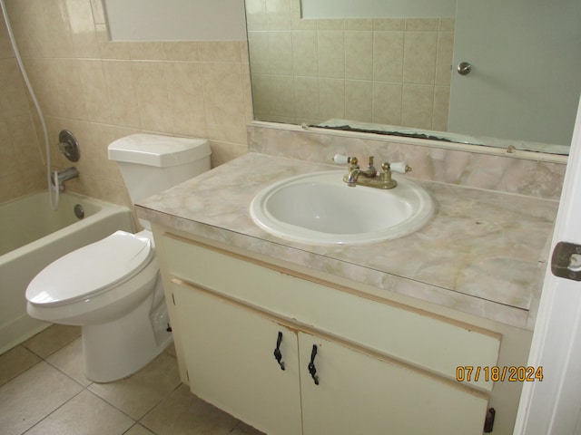 full bathroom with tile patterned flooring, tiled shower / bath combo, toilet, vanity, and tile walls