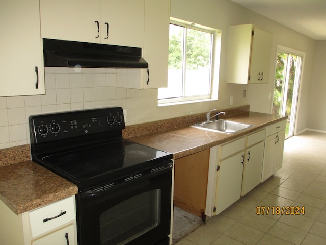 kitchen featuring light tile patterned flooring, sink, black / electric stove, and white cabinetry