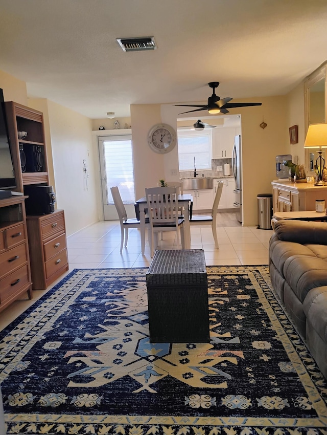 living room featuring sink, light tile patterned floors, and ceiling fan