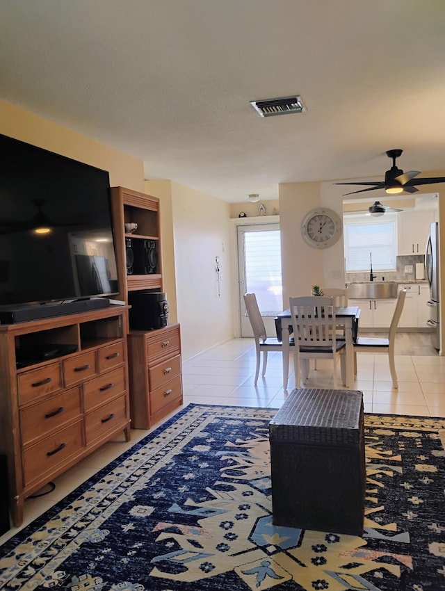 tiled living room with ceiling fan