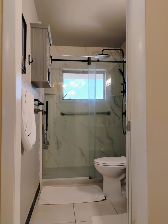 bathroom with toilet, a shower with door, and tile patterned flooring