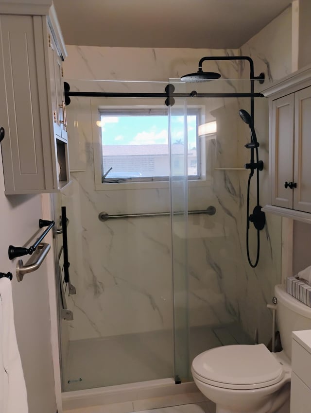 bathroom featuring a healthy amount of sunlight, a shower with door, and toilet