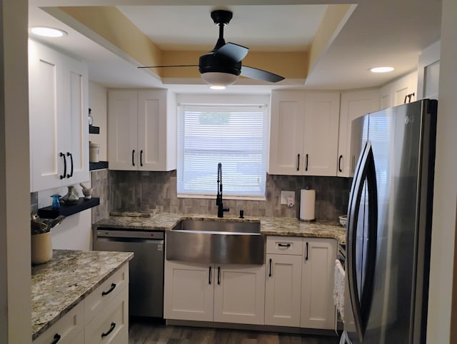 kitchen with white cabinetry, dark hardwood / wood-style flooring, stainless steel appliances, decorative backsplash, and sink