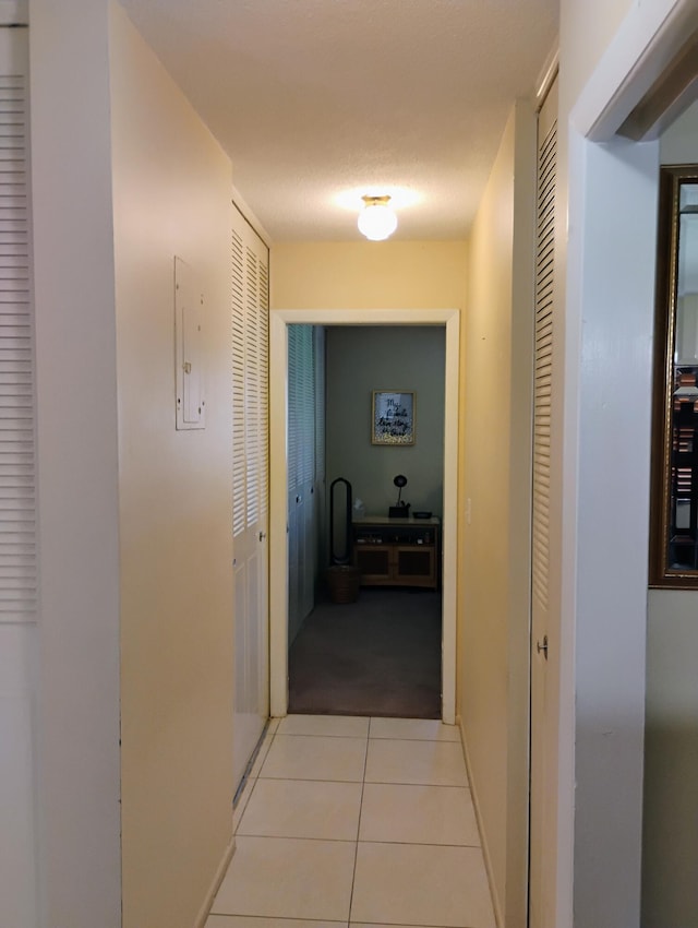 hallway with electric panel and light colored carpet