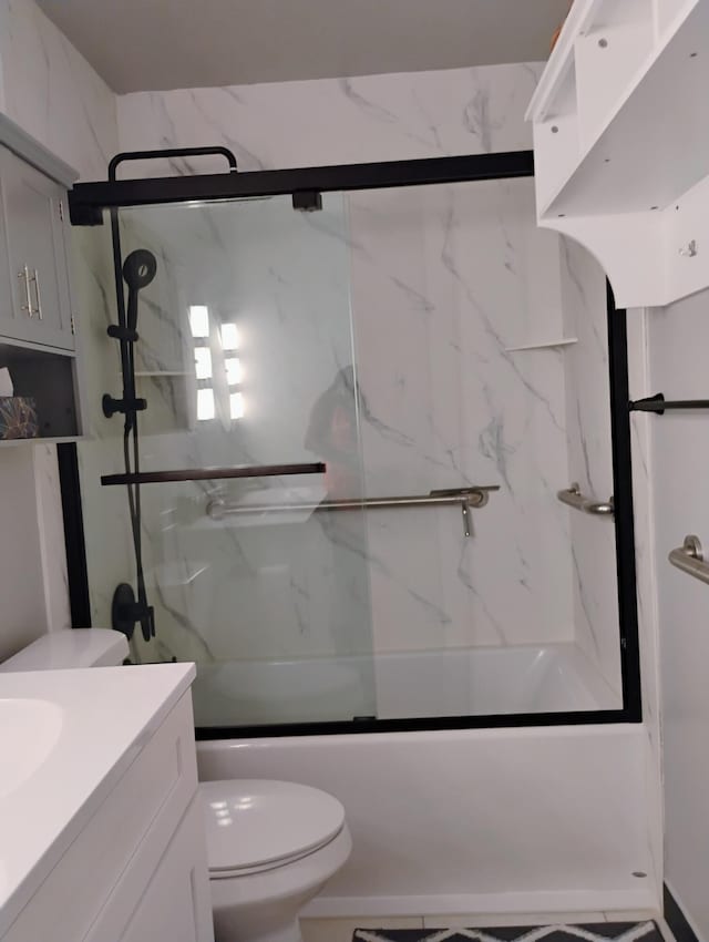 full bathroom featuring vanity, shower / bath combination with glass door, and toilet