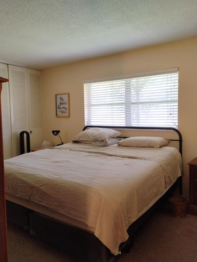 carpeted bedroom featuring multiple windows and a textured ceiling