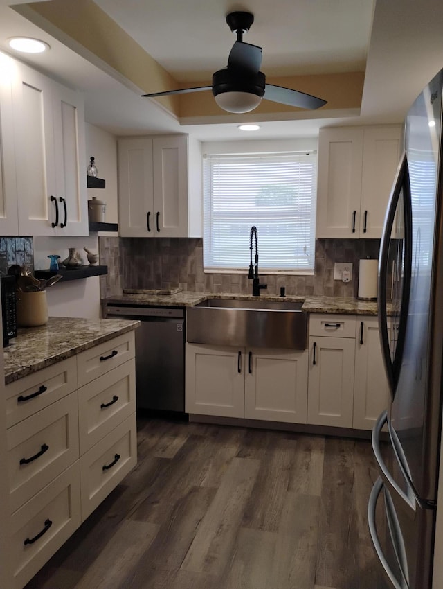 kitchen featuring white cabinets, sink, dark hardwood / wood-style floors, appliances with stainless steel finishes, and backsplash