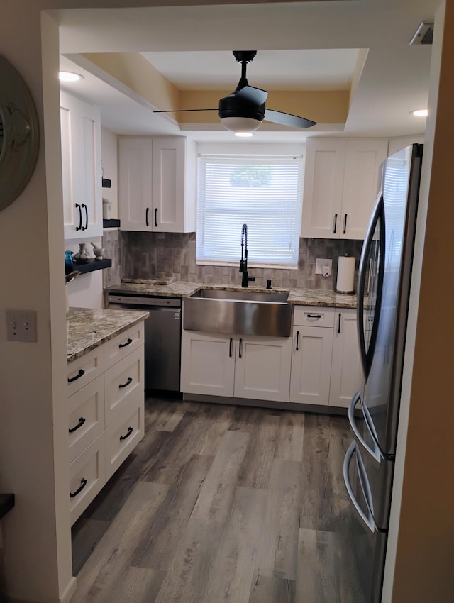 kitchen featuring sink, white cabinetry, hardwood / wood-style floors, and stainless steel appliances