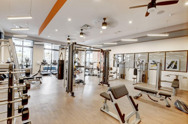 gym with ceiling fan and light hardwood / wood-style floors