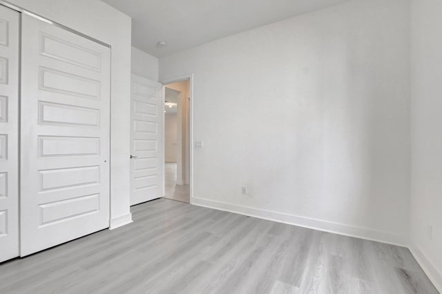 unfurnished bedroom featuring a closet and light wood-type flooring