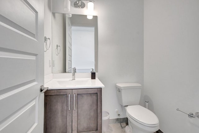 bathroom featuring tile patterned flooring, toilet, and vanity