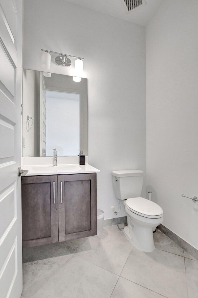 bathroom featuring vanity, tile patterned flooring, and toilet