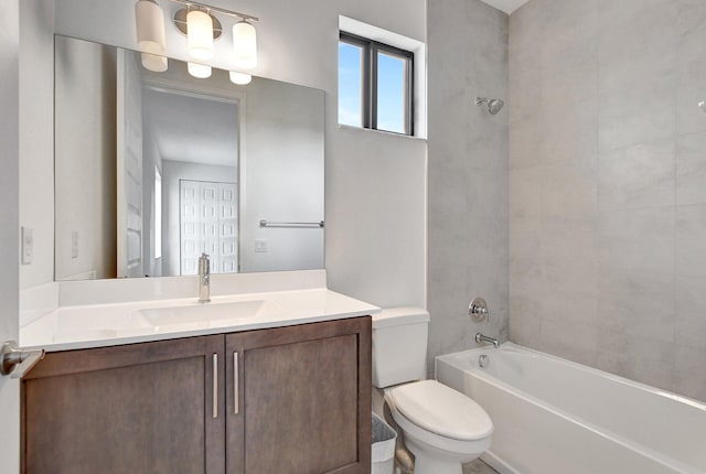 full bathroom featuring vanity, tiled shower / bath combo, and toilet