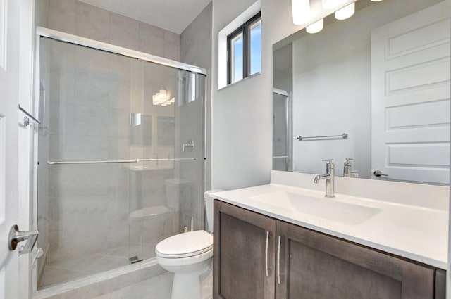 bathroom with tile patterned floors, vanity, walk in shower, and toilet