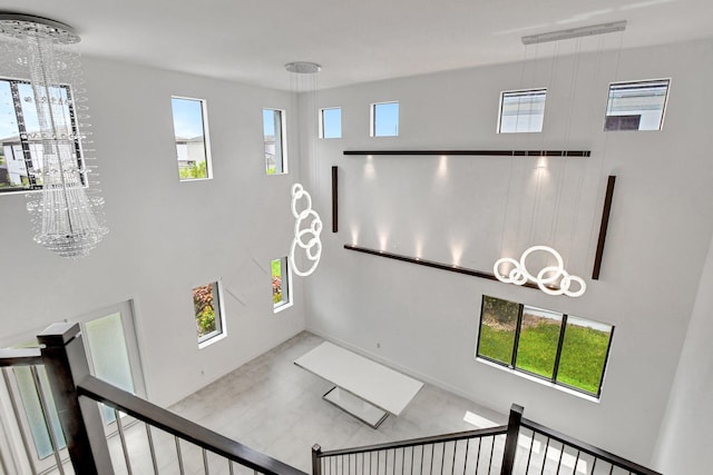 stairway with an inviting chandelier, hardwood / wood-style floors, and plenty of natural light