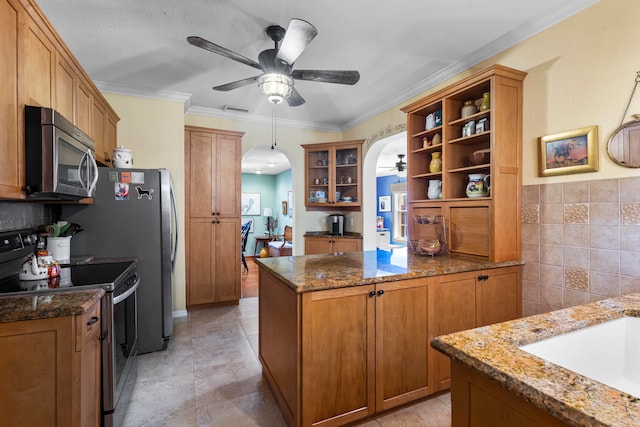 kitchen with ceiling fan, stainless steel appliances, pendant lighting, ornamental molding, and light tile patterned floors