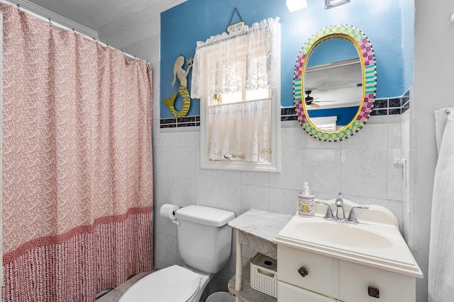 bathroom with tile walls, toilet, vanity, and ornamental molding