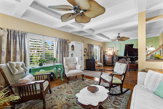 living room with ceiling fan, wood-type flooring, beam ceiling, and coffered ceiling