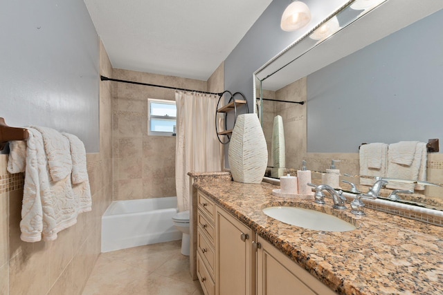 full bathroom with tile patterned floors, toilet, tile walls, vanity, and shower / bath combo with shower curtain