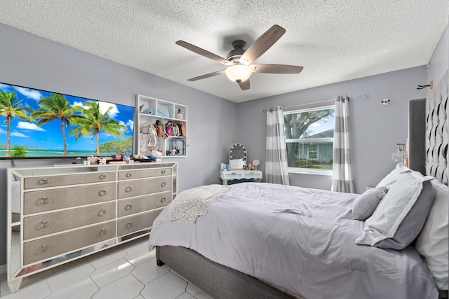 tiled bedroom featuring ceiling fan and a textured ceiling